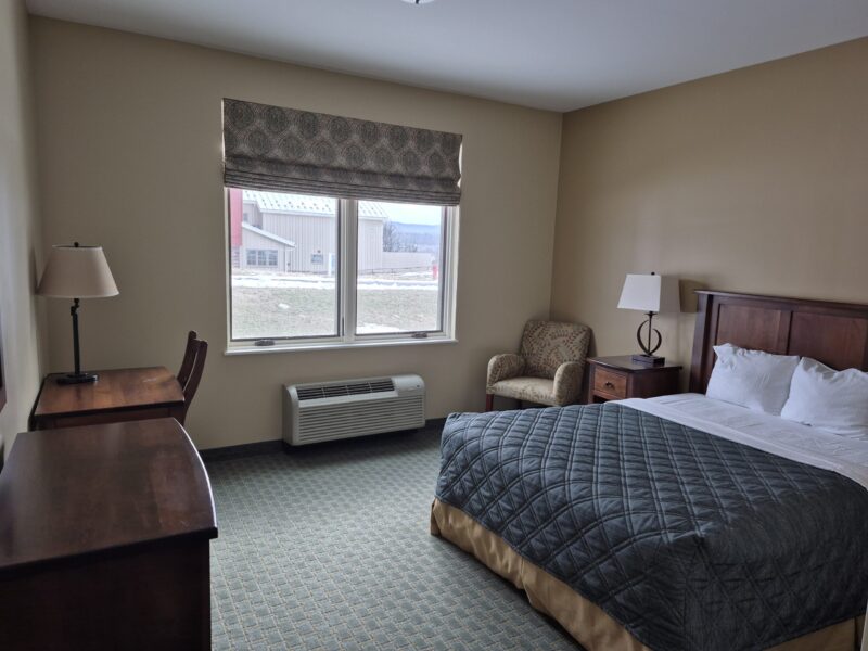 Copy of Inn Single Room Historic brick building with cupola and chimney, surrounded by lush trees. The scene conveys a serene, timeless atmosphere, blending architecture with nature.
