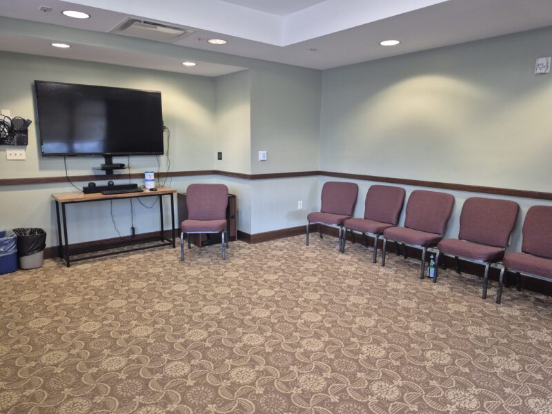 tidball walker rooms A large, traditional white house with a porch and gabled roof, surrounded by trees and a green lawn under a partly cloudy sky.