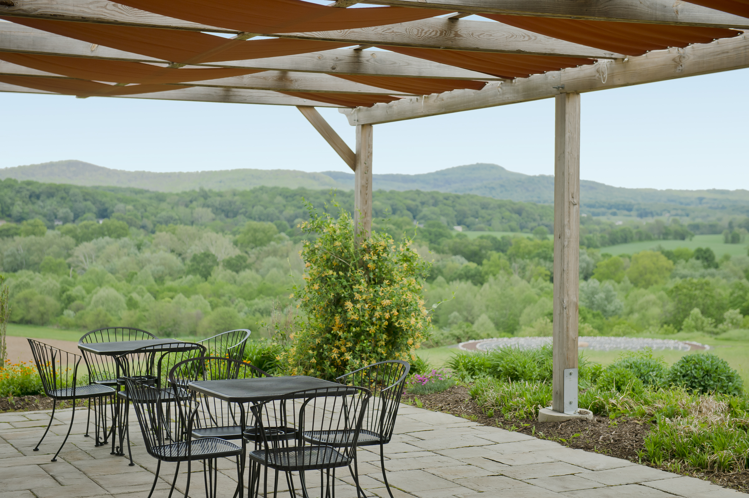 image of claggett dining patio overlooking outdoor labyrinth with the skyline of sugarloaf mountain in the distance