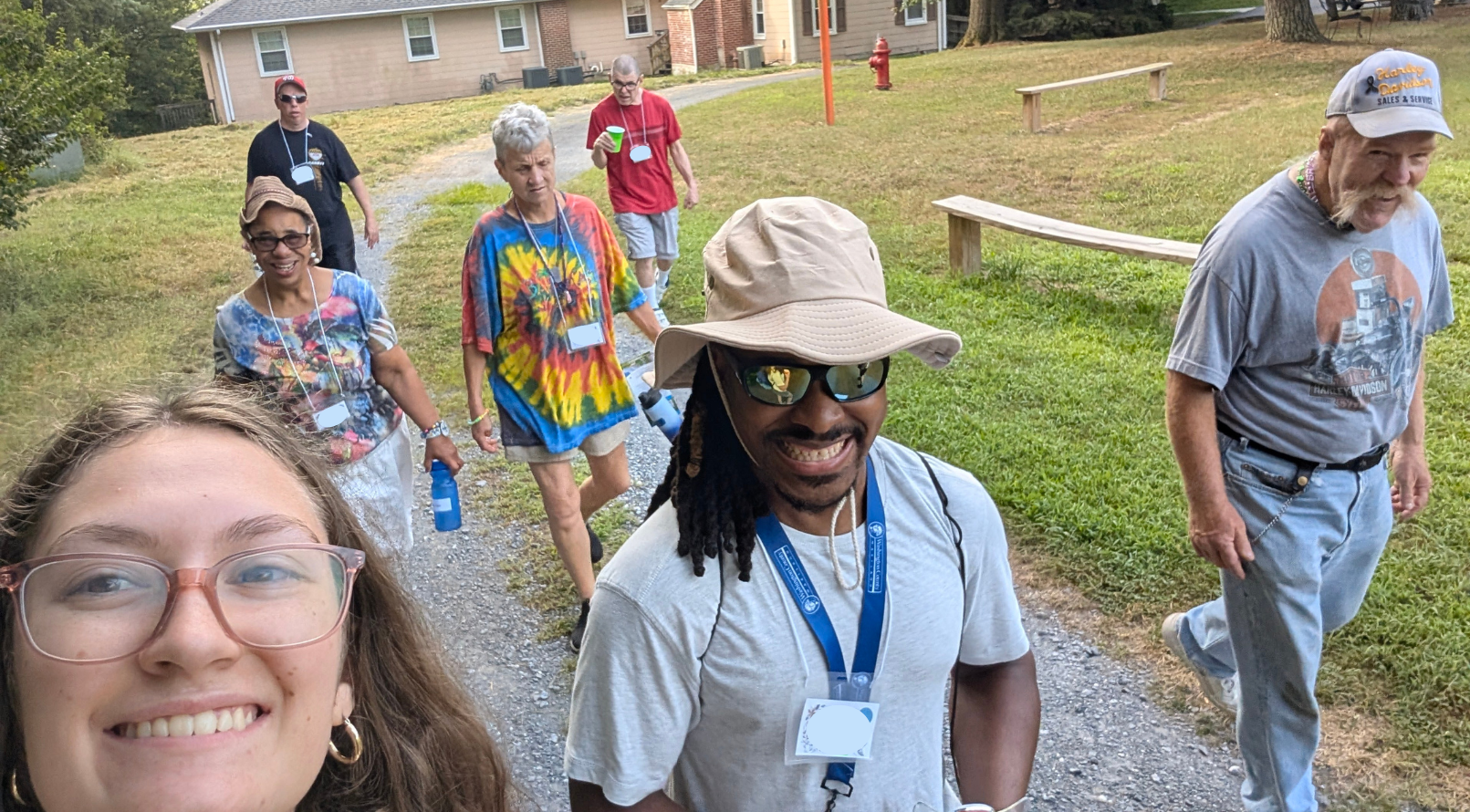 A lively gathering of people dancing in a wooden barn, adorned with string lights, creating a festive and cheerful atmosphere.